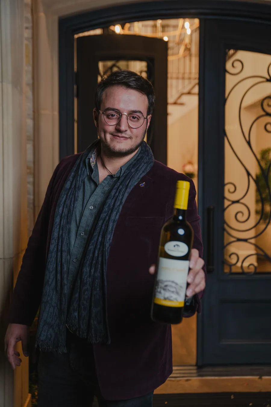 Aldo Bove, founder and winemaker of Above Wines, holding a bottle of white wine